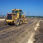 Motorgrader with GPS provides finished subgrade profile and blue topping.
