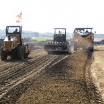 Multiple passes with vibratory padded drum roller immediately following tillage without delay to maximize strength of soil-fly ash mixture.